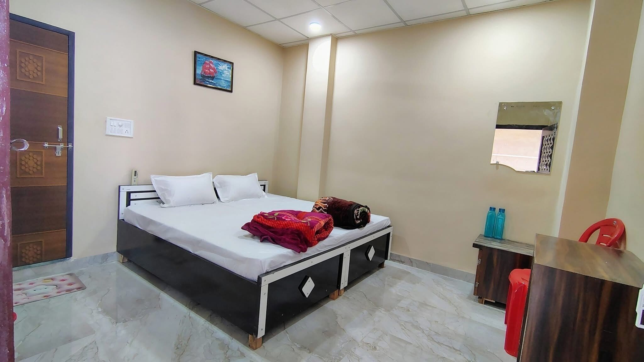 A hotel room with a bed, a desk, and a chair.