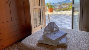 A room with a bed, a window, and a view of a balcony with a potted plant. - Albergo Regina Mundi (Pietra Ligure)