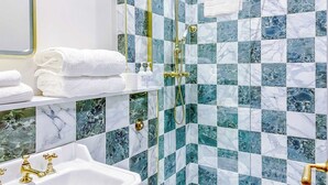A bathroom with a white sink, gold fixtures, and a shower with a gold showerhead. - Railway House -Platform 5, 1 Bedroom Apartment. (York)