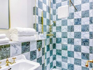 A bathroom with a white sink, gold fixtures, and a shower with a gold showerhead. - Railway House -Platform 5, 1 Bedroom Apartment. (York)