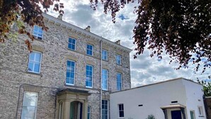 A two-story building with a stone facade and a white annex. - Railway House -Platform 5, 1 Bedroom Apartment. (York)