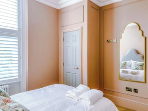 A hotel room with a bed, a door, a mirror, and a window with blinds. - Railway House -Platform 5, 1 Bedroom Apartment. (York)
