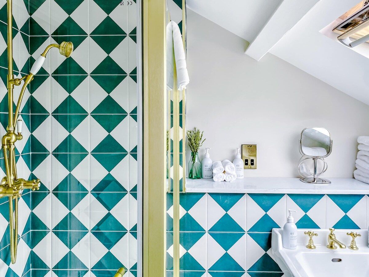 A bathroom with a shower, a sink, and a mirror.
