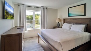 A bedroom with a large bed, a desk, a TV, and a window with curtains. - Ruby 314: 2BD | Great LOCATION + Shared Amenities! (Pigeon Forge)