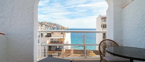 Un balcone con vista sul mare, un tavolo e una sedia.