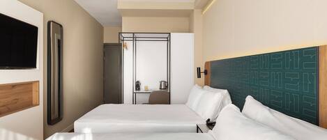 A hotel room with a bed, a desk, a chair, a television, and a wall-mounted mirror.