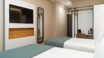 A hotel room with two beds, a TV, a mirror, a wardrobe, and a shower area.