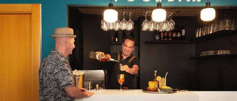 A bar area with a sign reading 'POOL BAR' and a bartender preparing drinks.