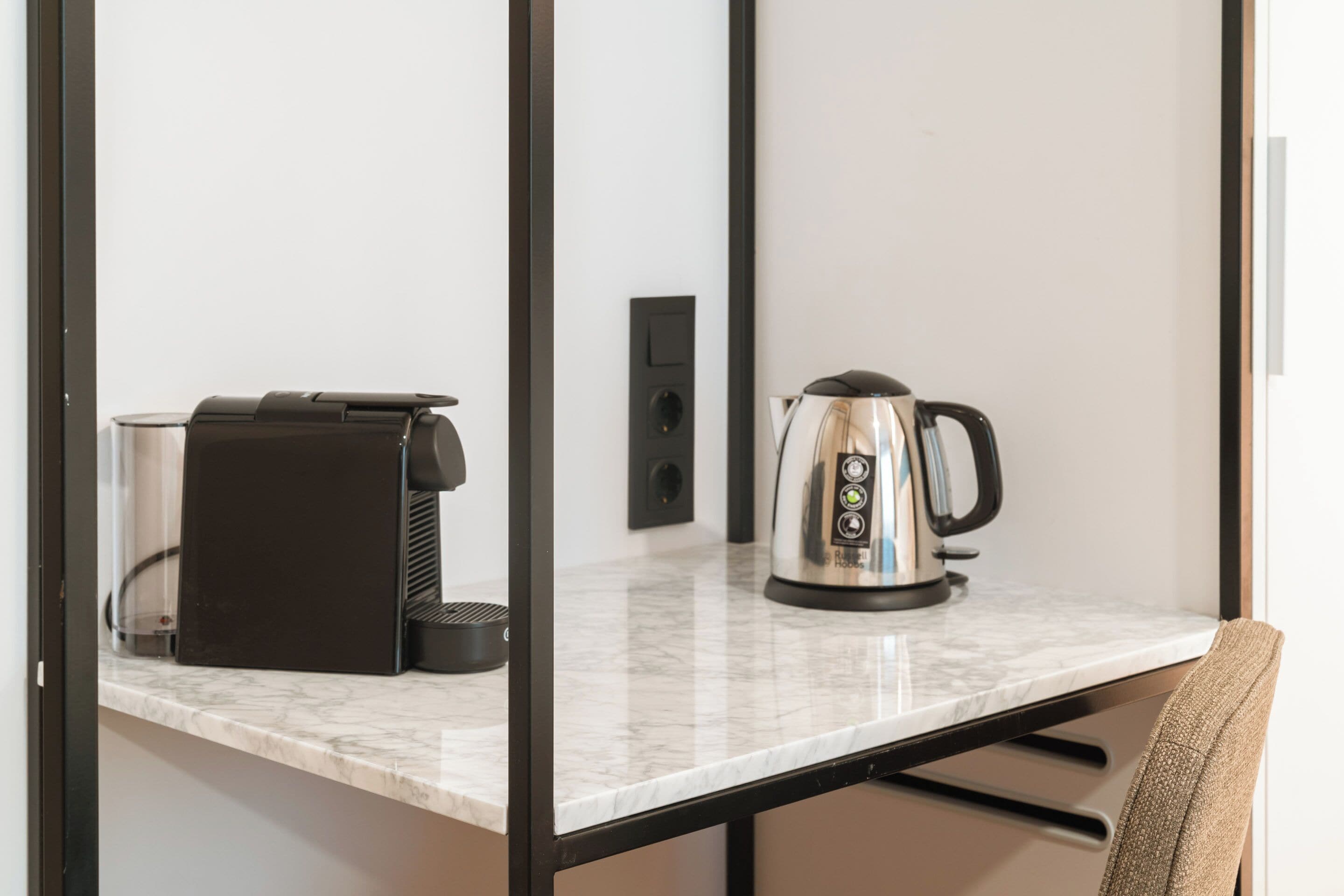 Eine Küchenarbeitsplatte mit einer Kaffeemaschine und einem Wasserkocher.
