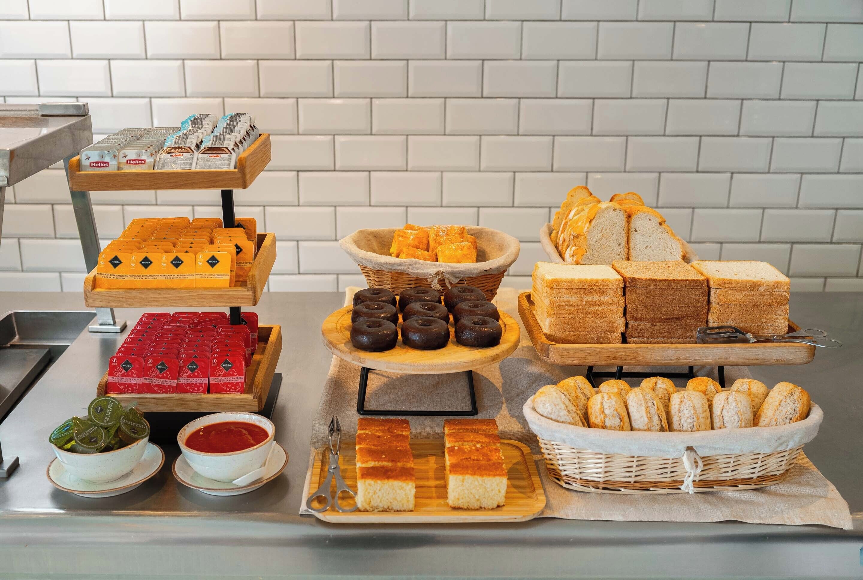 Ein reichhaltiges Buffet mit verschiedenen Speisen, darunter Brot, Gebäck und Beilagen.