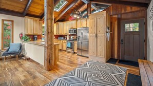 A spacious kitchen with wooden cabinets, a large island, and a stainless steel refrigerator.