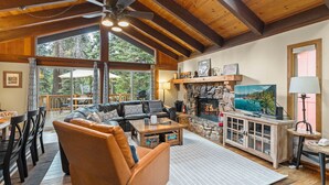 A cozy living room with a fireplace, leather sofa, and a television.