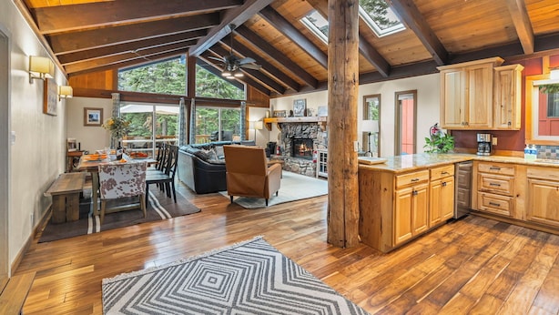 A spacious kitchen with wooden cabinets and a stone fireplace.