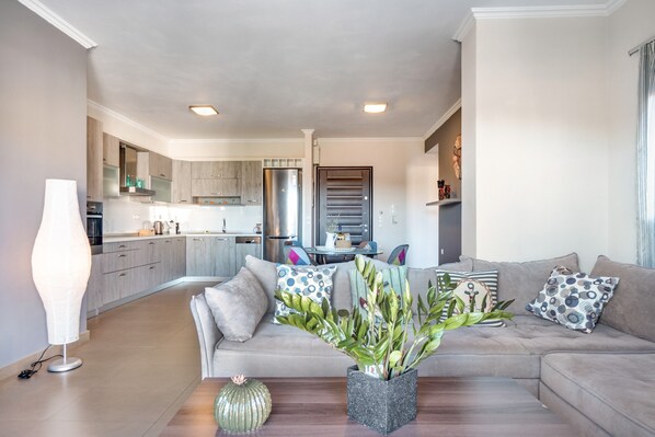 A modern living room with a sofa, a coffee table, and a plant centerpiece.