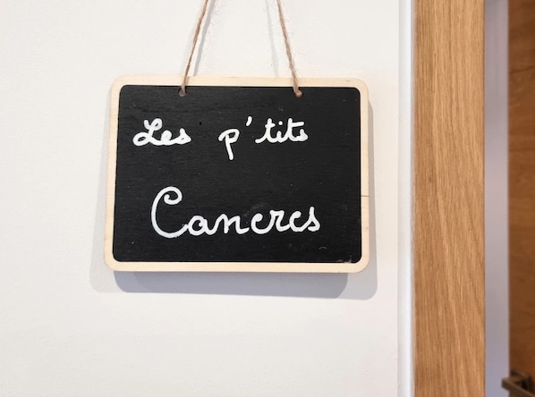 Un tableau noir avec du texte blanc, encadré en bois, accroché à un mur blanc.