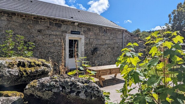 A stone building with a tiled roof, a wooden bench, and a sign reading 'L'école brissommière'. - Cottage “L'École Buissonnière de Mazalibrand”: Mountain View, Private Terrace & Garden (Mazet-Saint-Voy)