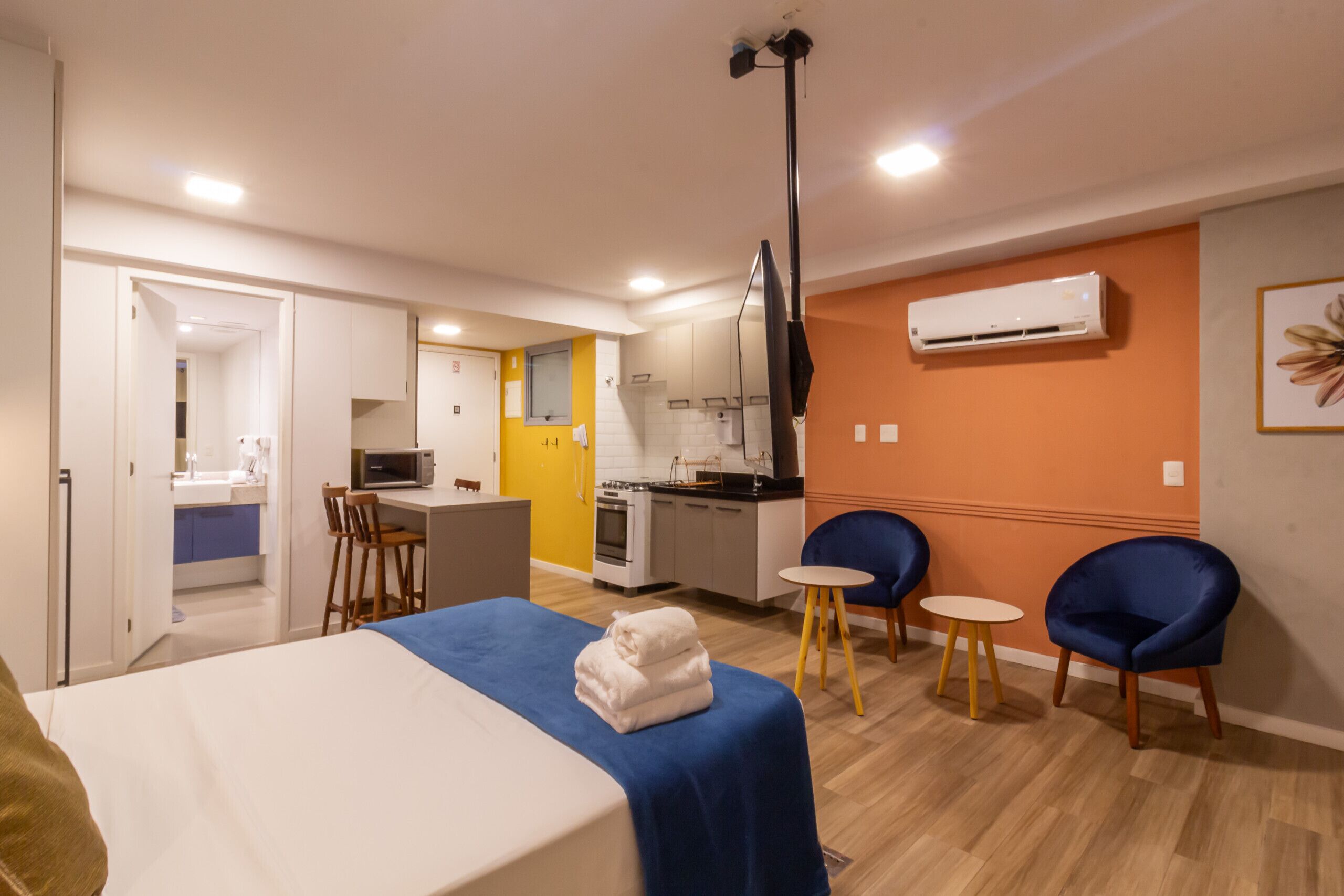 Una habitación de hotel con una cama, un escritorio, una silla, una mesita y un rincón americano.
