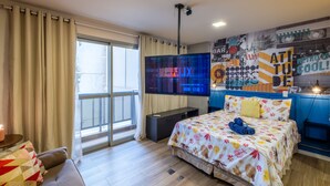 A modern hotel room with a large bed, a TV, a balcony, and a wall with motivational posters. - 4 Minutes From Arcos da Lapa M404b (Rio de Janeiro)