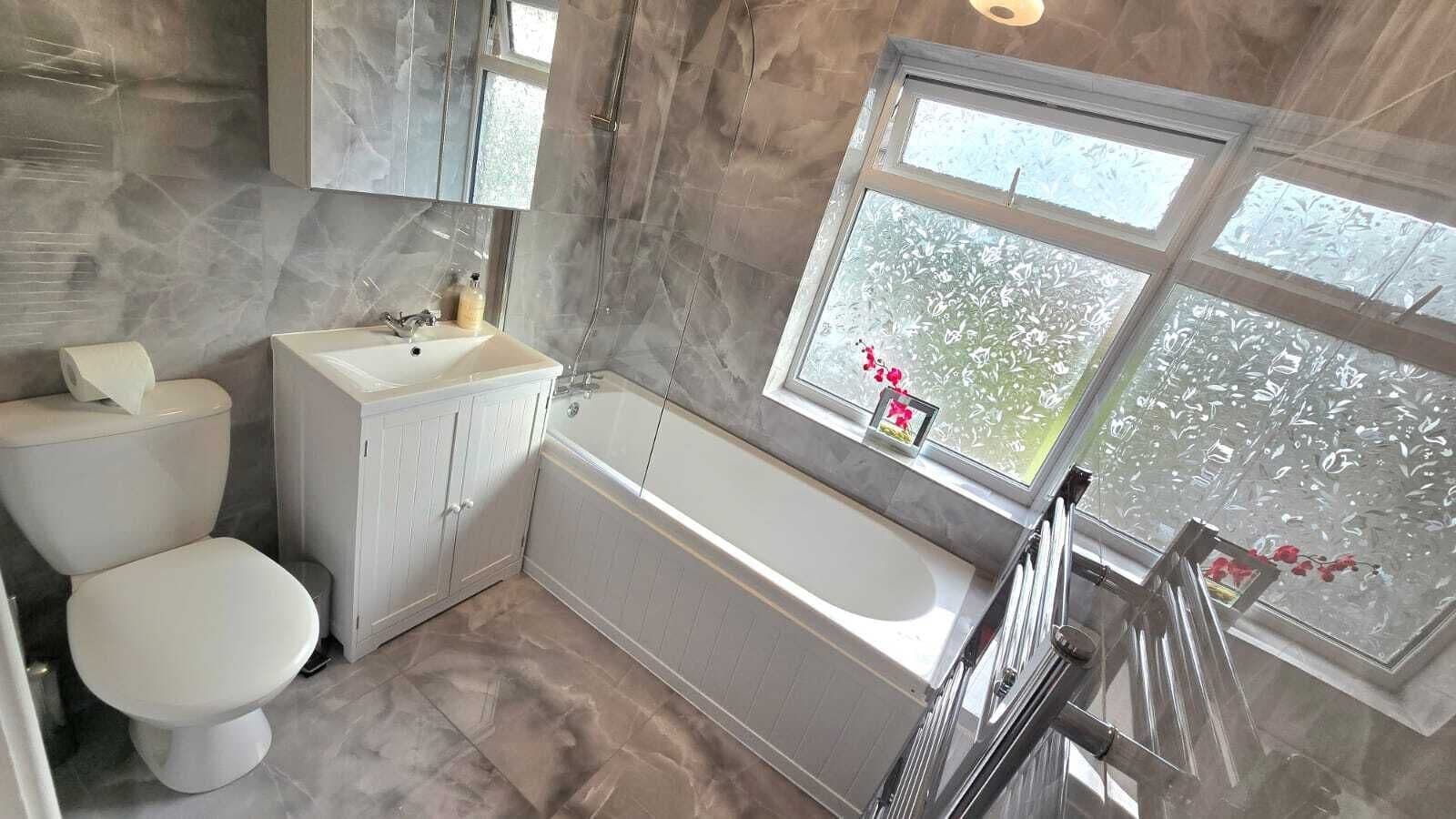 A bathroom with a toilet, sink, and bathtub.