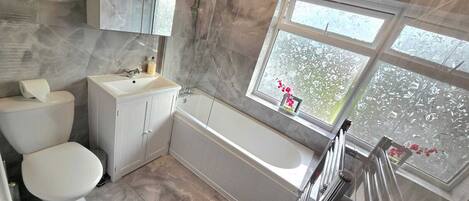 A bathroom with a toilet, sink, and bathtub.