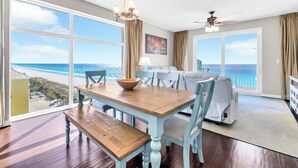 A spacious living room with a large window offering a view of the beach. - ⭐Beach Front | GULF VIEWS | HUGE Balcony | Pool | Sterling Reef 501⭐ (Panama City Beach)