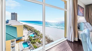 A room with a large window offering a view of a beach and ocean. - ⭐Beach Front | GULF VIEWS | HUGE Balcony | Pool | Sterling Reef 501⭐ (Panama City Beach)