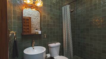 Baño con lavamanos, inodoro y cortina de ducha.