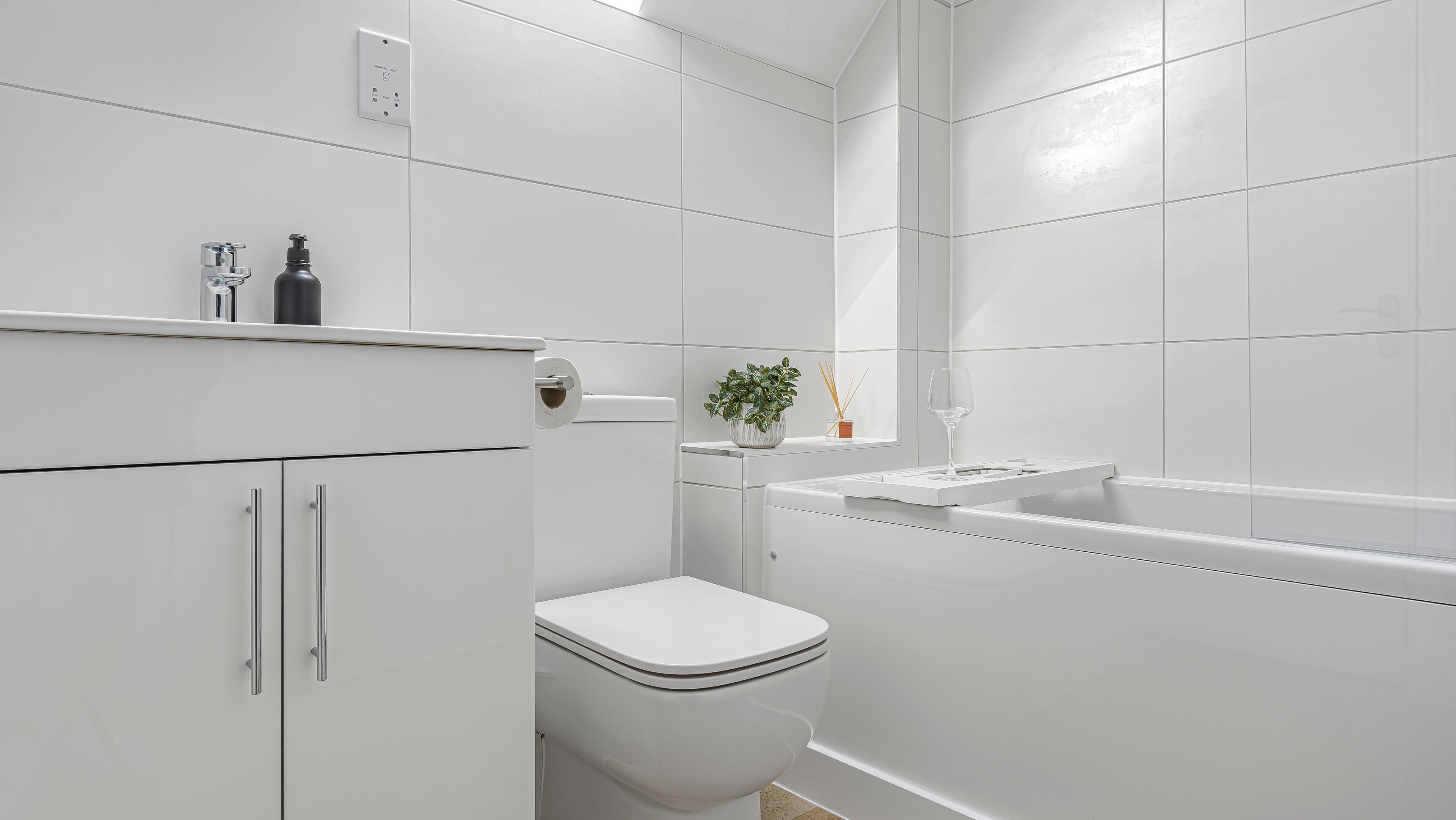 Een moderne badkamer met toilet, wastafel en douche.