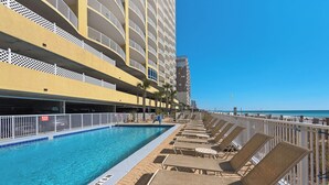 Zona junto a la piscina con sillones de descanso y una piscina.
