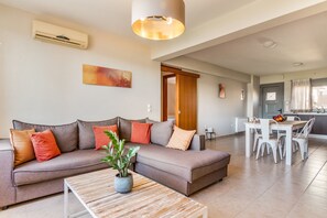 A modern living room with a sofa, coffee table, and dining area.