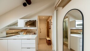 Una cocina moderna con armarios blancos, horno empotrado y una isla grande con fregadero.