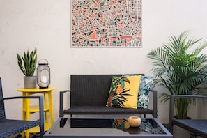A modern outdoor seating area with a sofa, chairs, a small table, and potted plants. - Silent home retreat (5 min Centrale Station) (Milan)