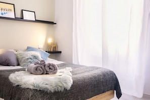 A neatly made bed with rolled towels, a fluffy white rug, and a bedside table with a lamp. - Silent home retreat (5 min Centrale Station) (Milan)