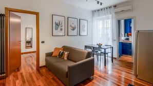 Een moderne woonkamer met een bank, een eettafel en een keukenhoek.