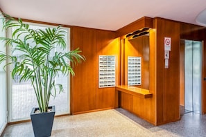 Un intérieur en bois agrémenté d’une plante en pot, d’un banc et d’un présentoir fixé au mur.