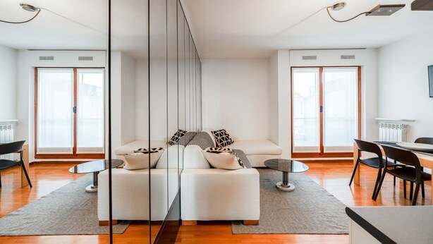Un salon moderne avec un canapé, une table basse et un coin repas.