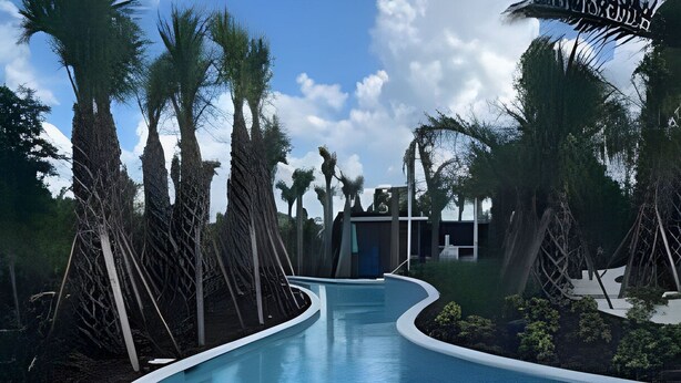 A swimming pool with a curved edge, surrounded by palm trees and a modern building in the background. - 5 Bd / 4,5 Ba / Sleeps 14 / Windsor Cay Resort (Clermont)
