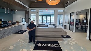 A modern hotel lobby with a reception desk, large windows, and a logo on the floor. - 5 Bd / 4,5 Ba / Sleeps 14 / Windsor Cay Resort (Clermont)