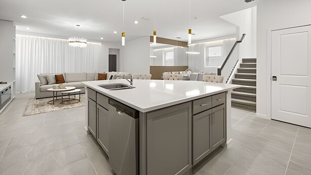 A modern kitchen with a central island, a dining area with a sofa, and a staircase leading to an upper level. - 7 Bd / 6.5 Ba / Sleeps 20 / Solara Resort (Kissimmee)