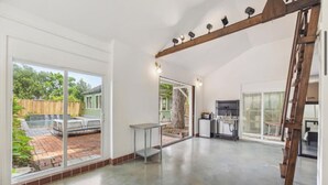 A spacious living area with a large sliding glass door leading to a backyard patio. - Pecan Pool House  - Garden Villa #2 (Houston)