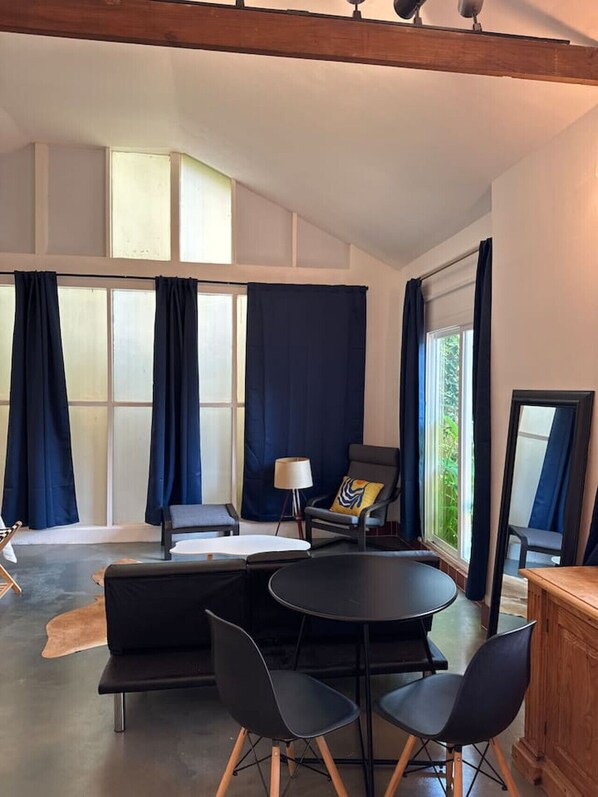 A modern room with a large window, a round table, and a sofa.