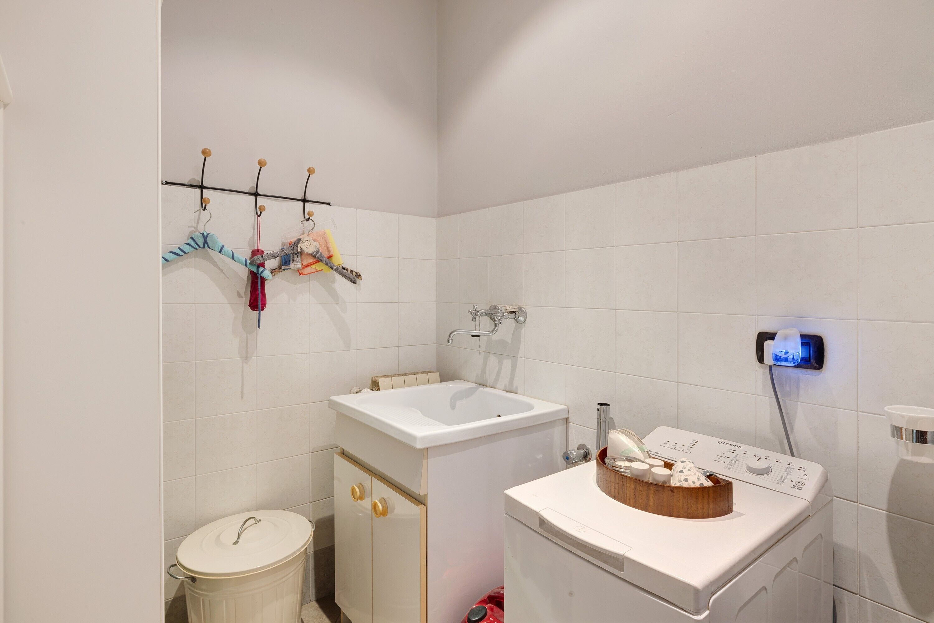A bathroom with a sink, toilet, and washing machine.