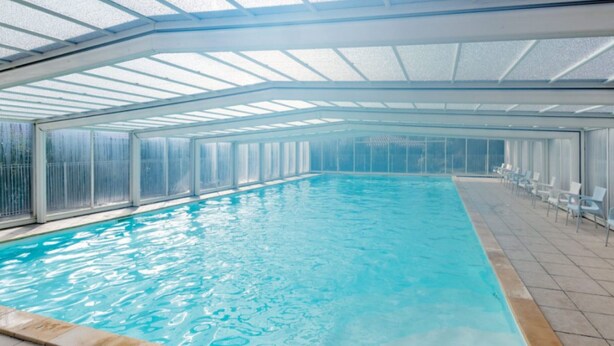 An indoor swimming pool with a glass ceiling, clear water, and a tiled floor. - Beautiful apart for 4 pers in the forest (Parentis-en-Born)