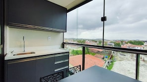 A modern kitchen with a large window, a sink, and cabinets. - Makani Beach Campas - Praia de Tamandaré (Tamandaré)