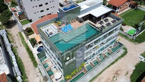 A modern building with a rooftop pool, multiple balconies, and a sign reading 'MAKAN'. - Makani Beach Campas - Praia de Tamandaré (Tamandaré)