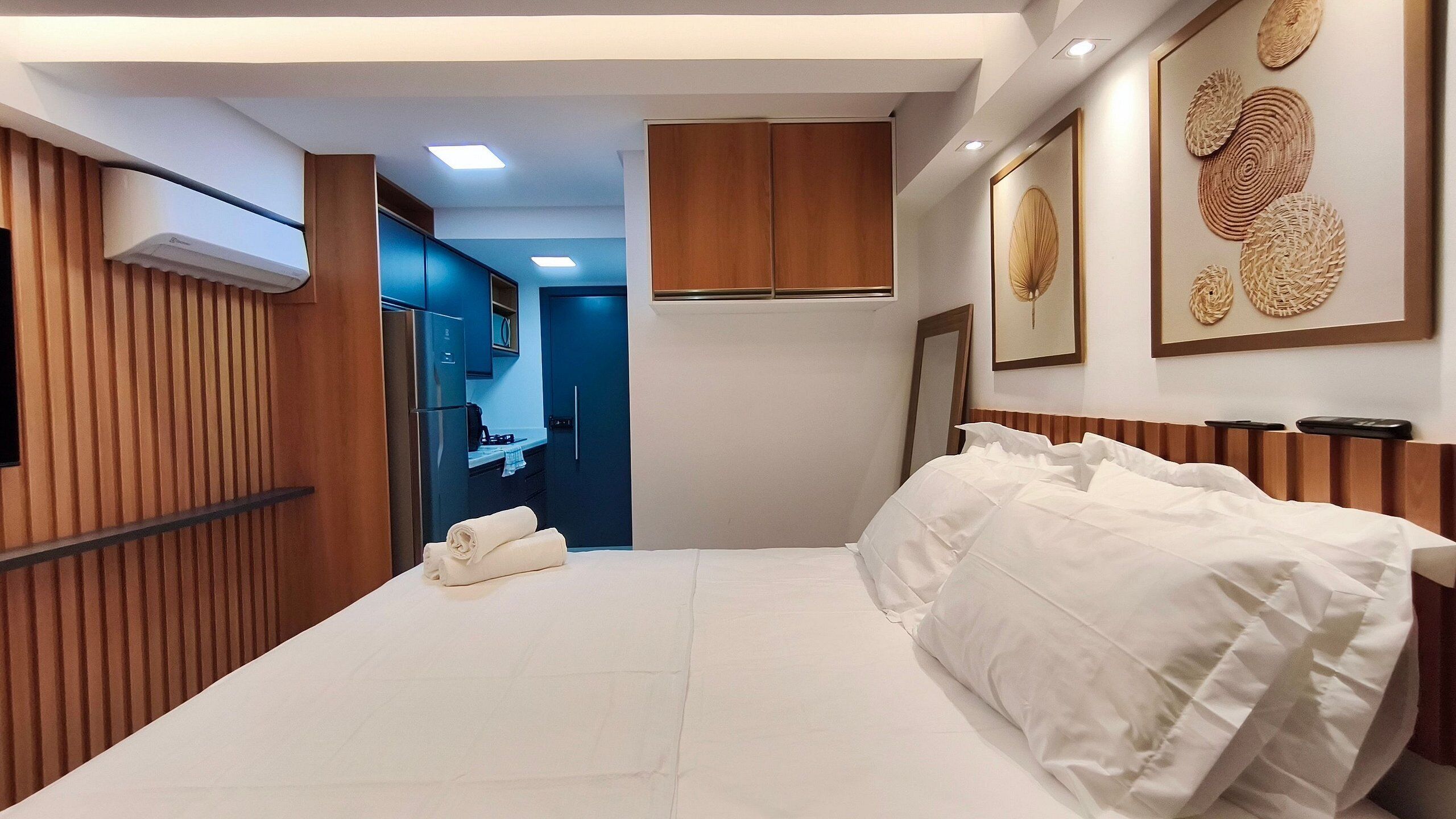 A hotel room with a bed, a bathroom, and a kitchenette.