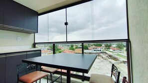 Cozinha moderna com uma grande janela dando vista para uma área residencial.