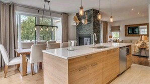 Una cocina moderna con una isla central, armarios de madera e iluminación colgante.