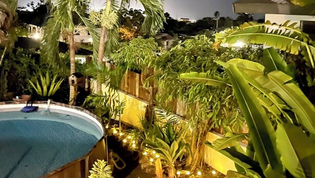 A pool surrounded by tropical plants and a wooden fence. - Harbour View - by Zenbreak (Lodge Hill)