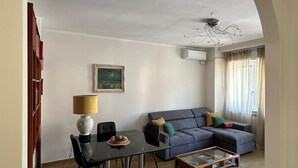 A living room with a dining area, a sofa, a coffee table, and a chandelier. - Centro Lecco [Dante Avenue]: Lake & Mountains (Lecco)